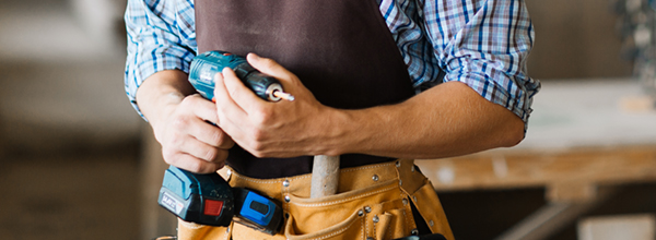 Smiling craftsman with electric drill