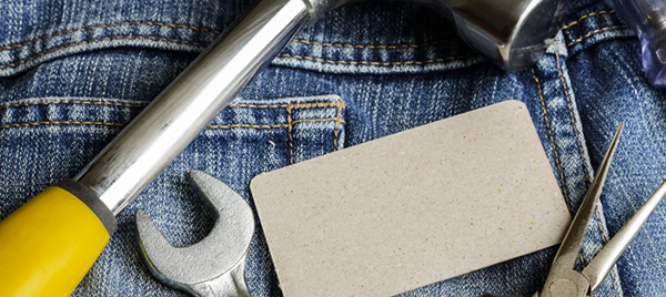 Several tools on a denim workers pocket